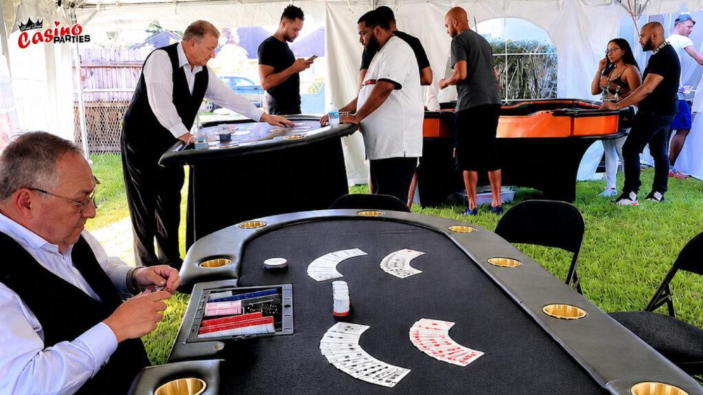 Professional dealers hosting poker and blackjack games under a white event tent for a backyard casino party in Florida.